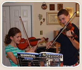 Students in holiday hats playing violin