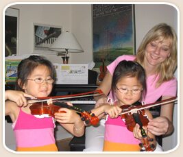 Anna Maksimiuk-Swic teaching two young violin students