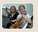 Two students playing violin together